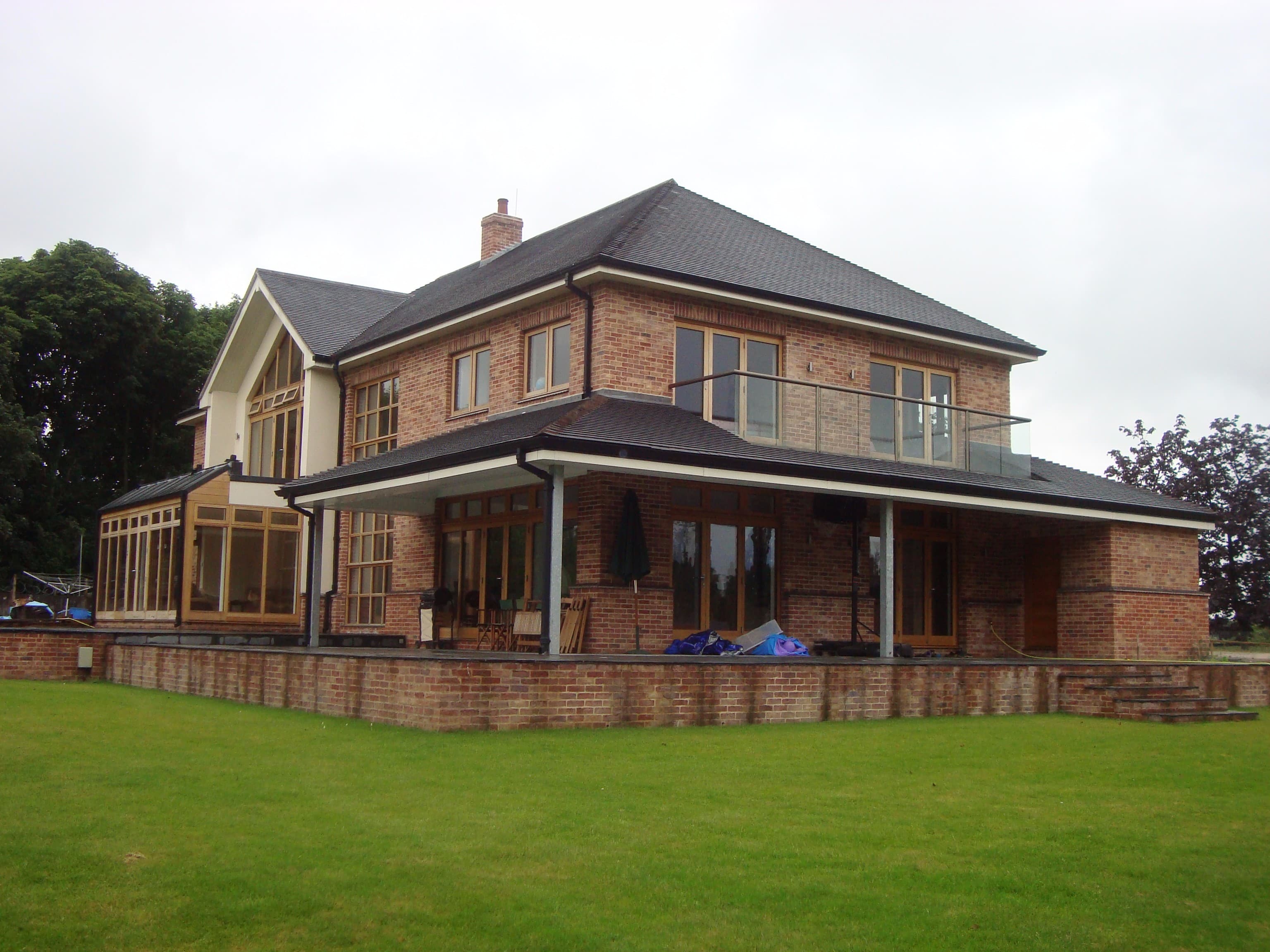 Two-storey new build with a glazed gable end and balcony